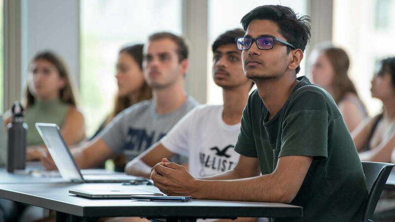 Male student listening to lecture in classroom